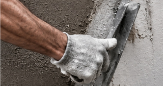 Travaux de maçonnerie et d'enduit Artisan réalisant des travaux d'enduit sur un mur